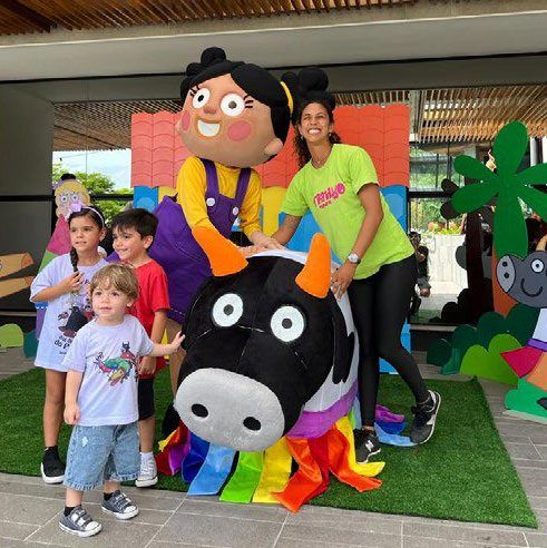 Crianças brincando com mascote em evento cultural