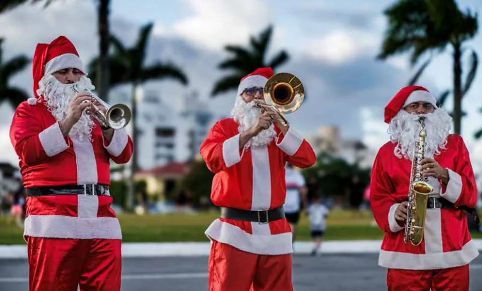 Banda de músicos vestidos de Papá Noel tocando en la Beira-Mar