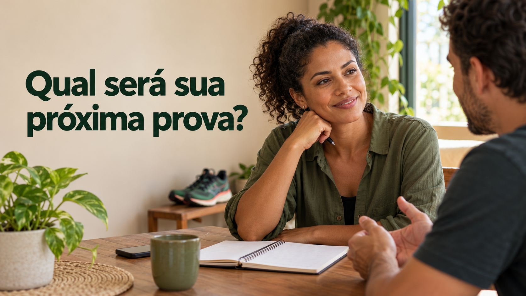Una corredora planea su próxima participación en la mesa de su casa, con un cuaderno abierto y un amigo al lado.